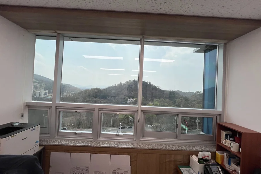 필름 시공 전 산 전망이 그대로 비치는 사무실 창가